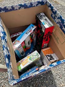 Corn Hole Fundraiser Toys for Tots collection box with toys.